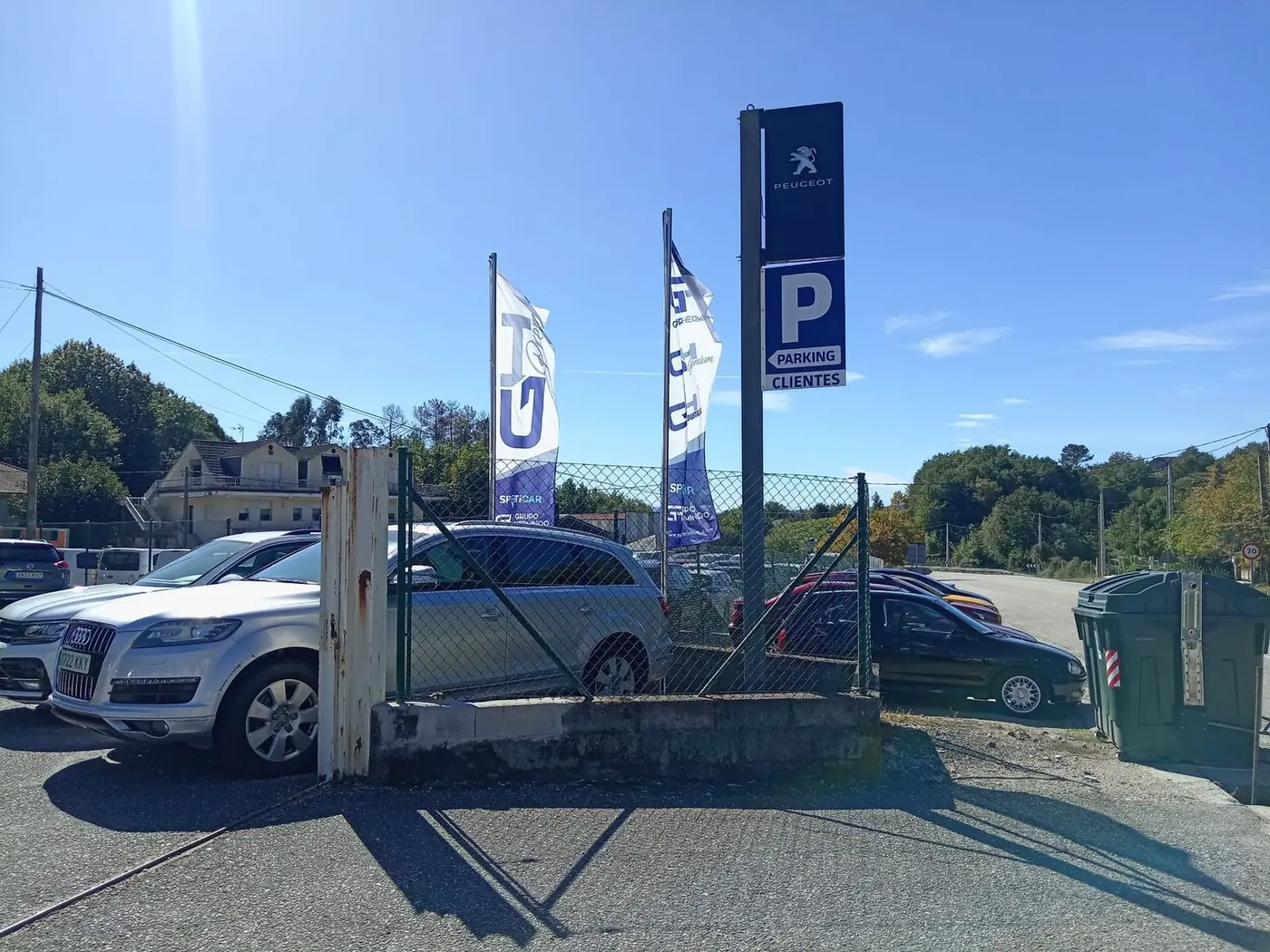 Banderas publicitarias de Sporticar junto a un cartel de aparcamiento en una zona de vehículos