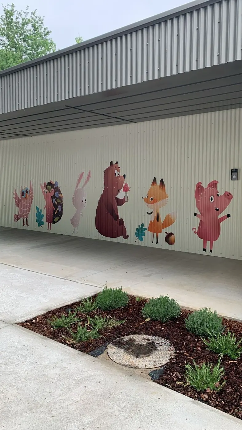 Mural de animales del bosque sobre la pared bajo la marquesina de entrada