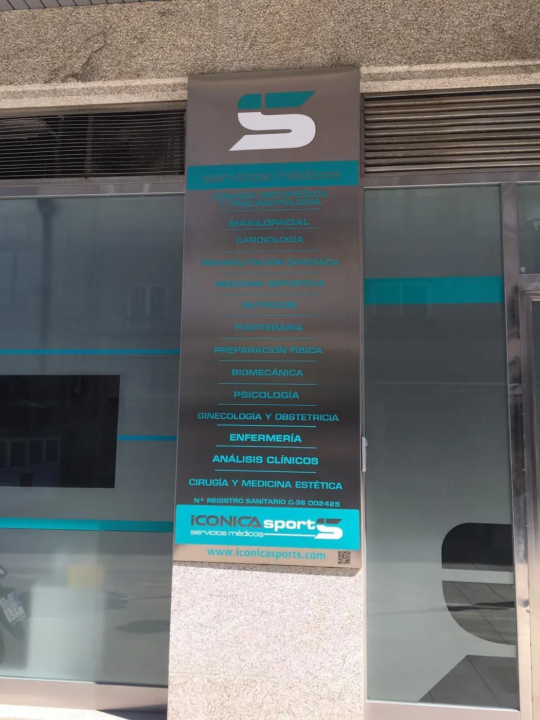 Directorio vertical de acero con el logotipo de Iconica y el listado de especialidades en vinilo turquesa