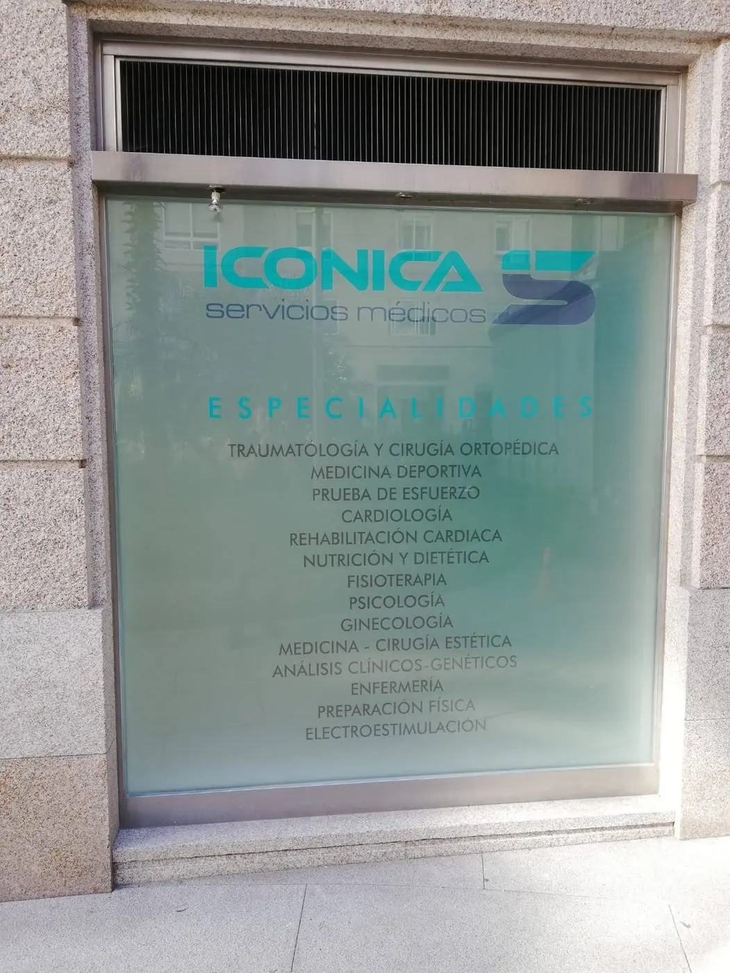 Escaparate esmerilado con el logotipo de Iconica y el listado de especialidades médicas