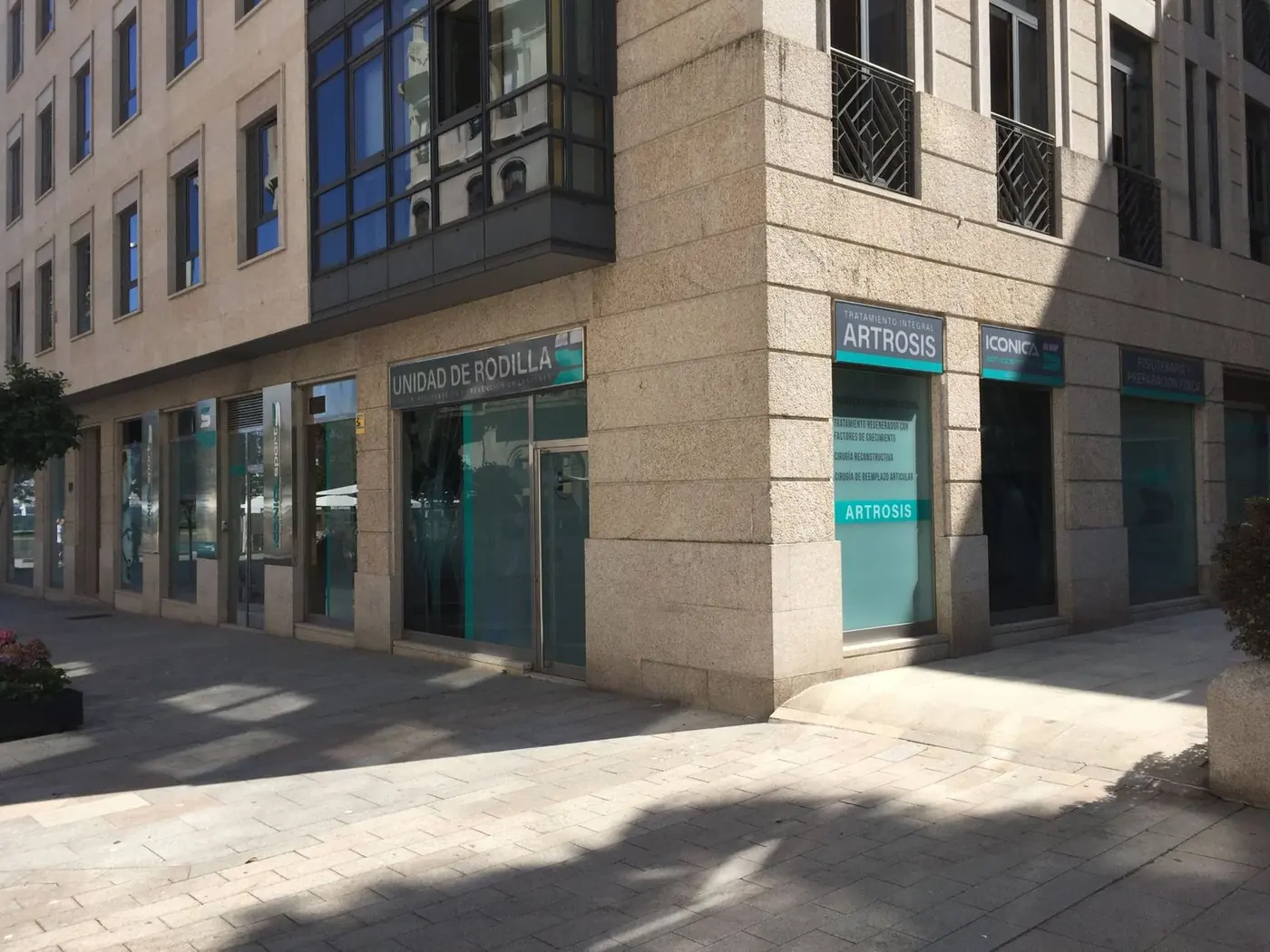 Esquina del edificio con los rótulos Unidad de Rodilla, Artrosis e Iconica sobre los escaparates