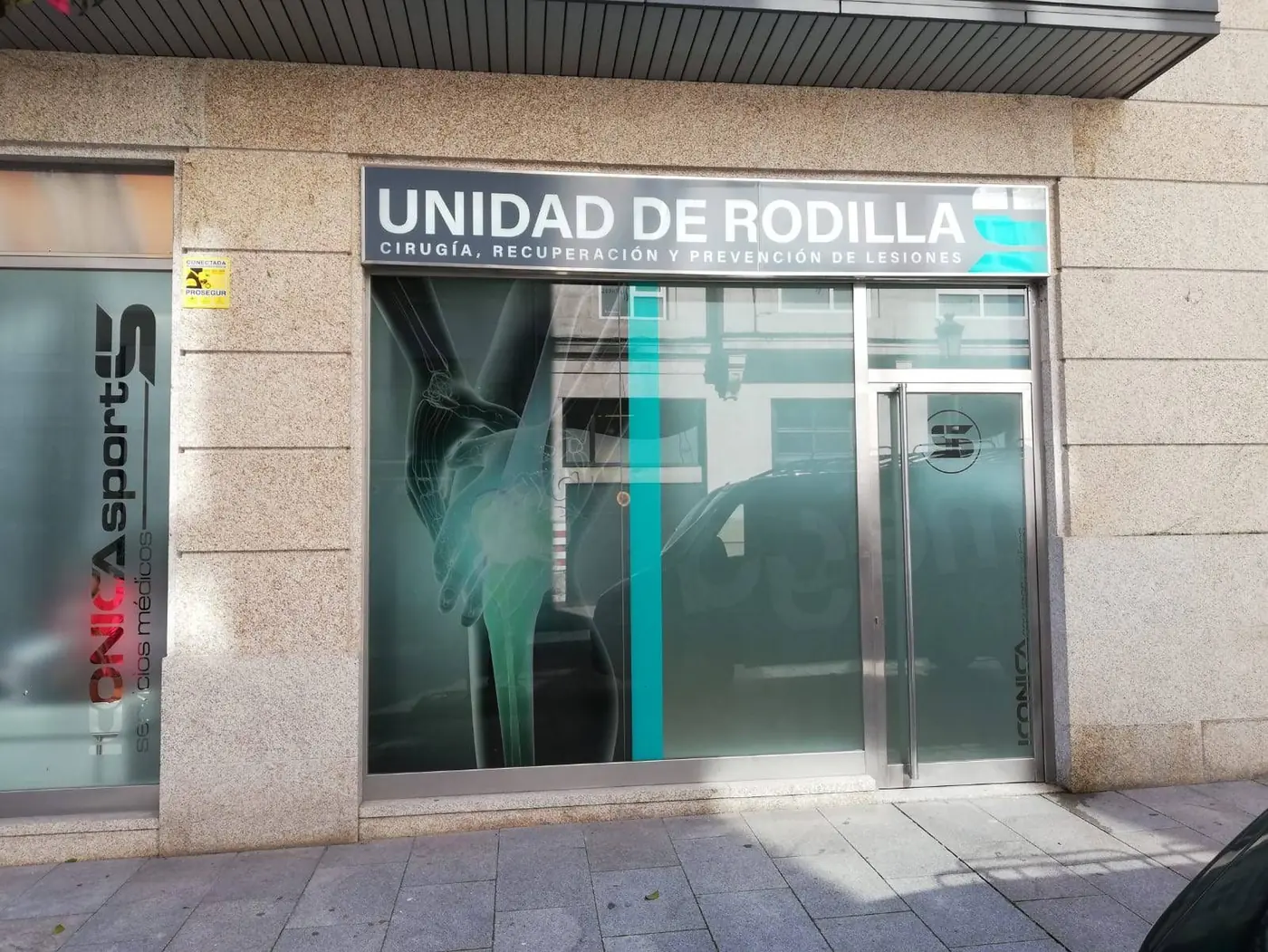 Fachada de la Unidad de Rodilla de Iconica con rótulo luminoso y vinilos con imágenes anatómicas