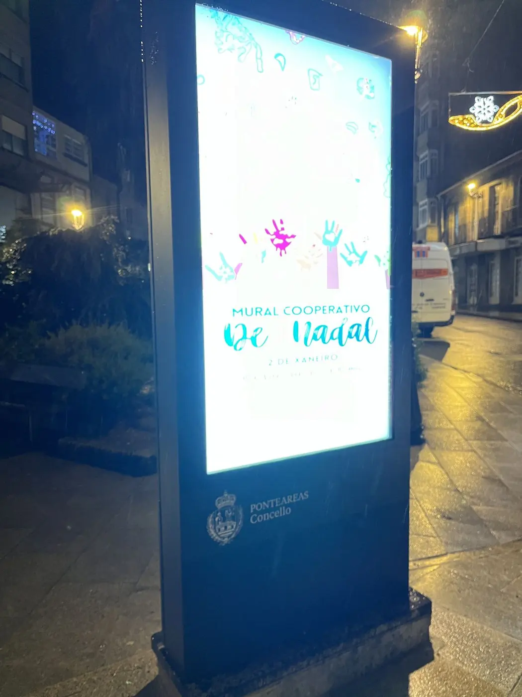 Mupi luminoso por la noche con cartel navideño del ayuntamiento