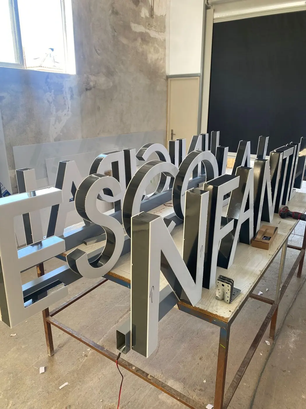 Letras corpóreas metálicas con luz en el taller antes de su instalación