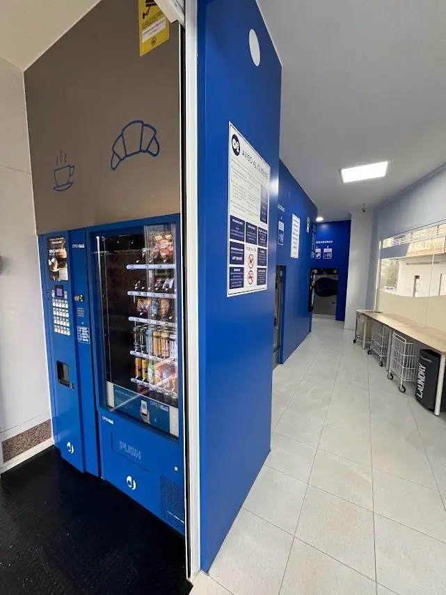 Máquina expendedora de OpenBlue con rotulación de café y cruasán sobre ella