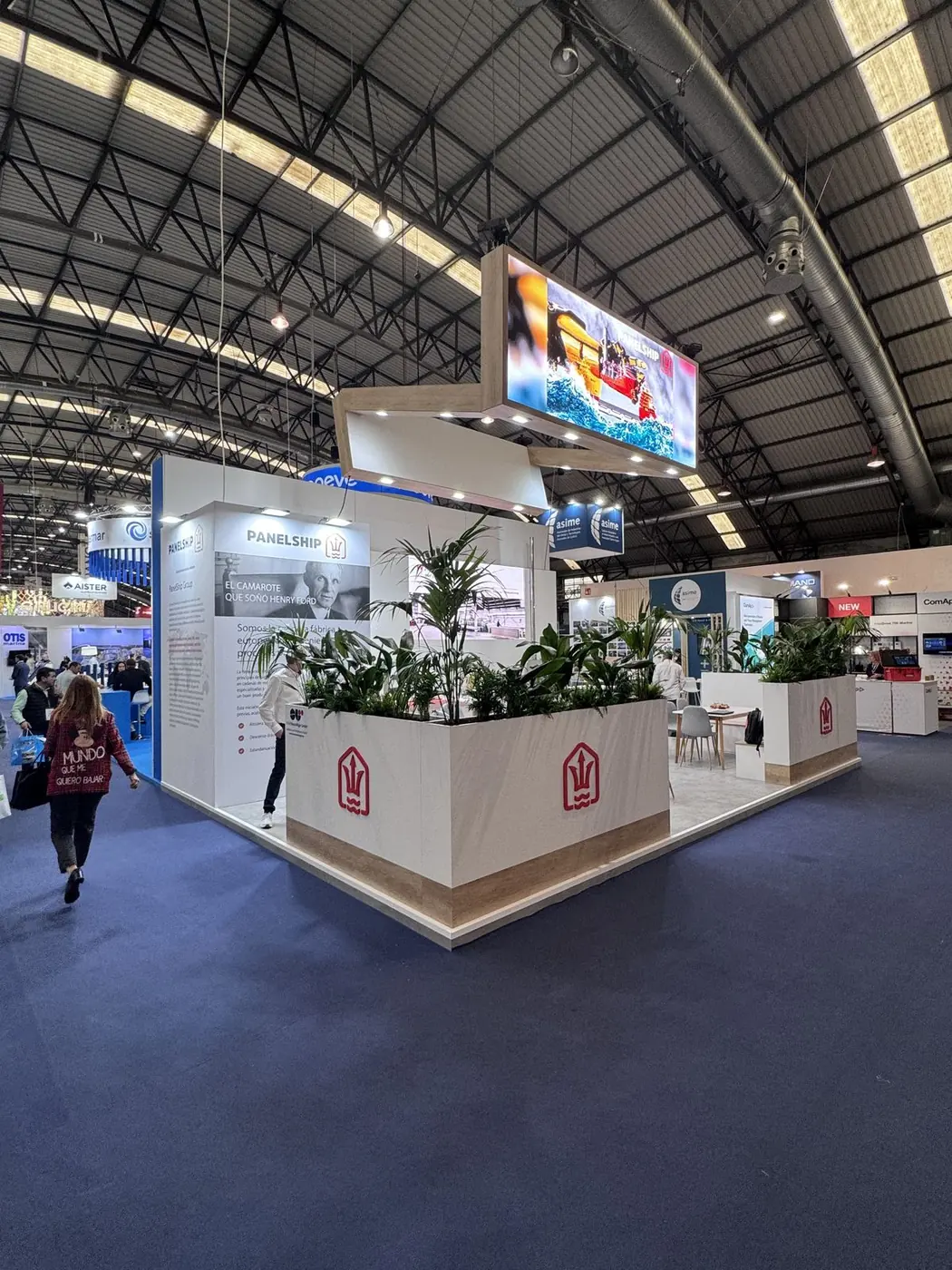 Otra vista del stand en la feria, con pantalla superior y jardineras