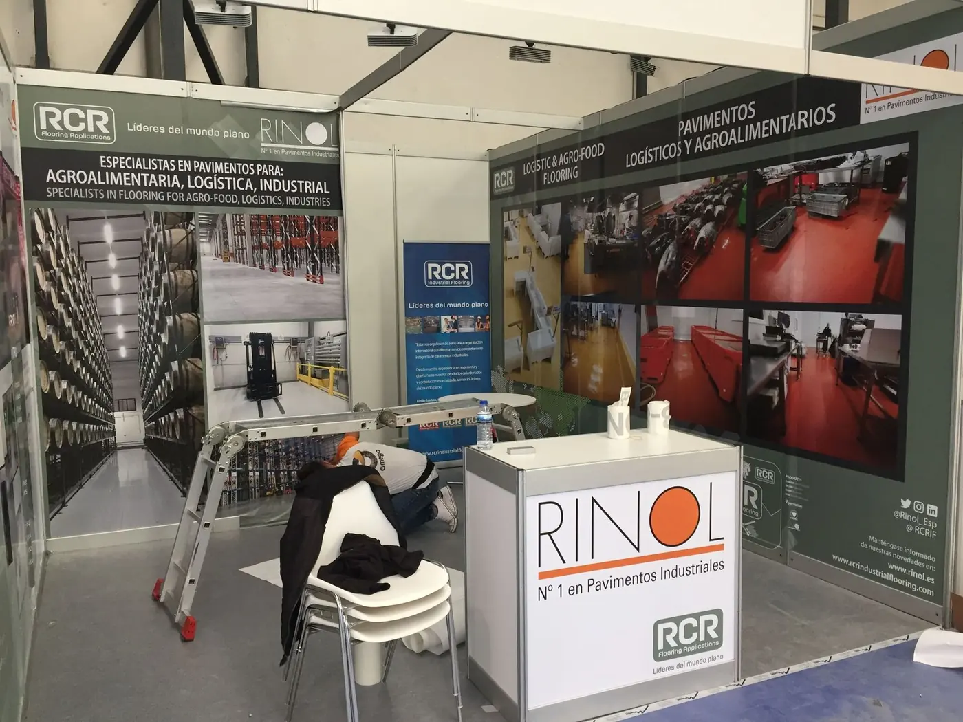 Stand de Rinol con paneles gráficos de pavimentos industriales y mostrador con el logotipo