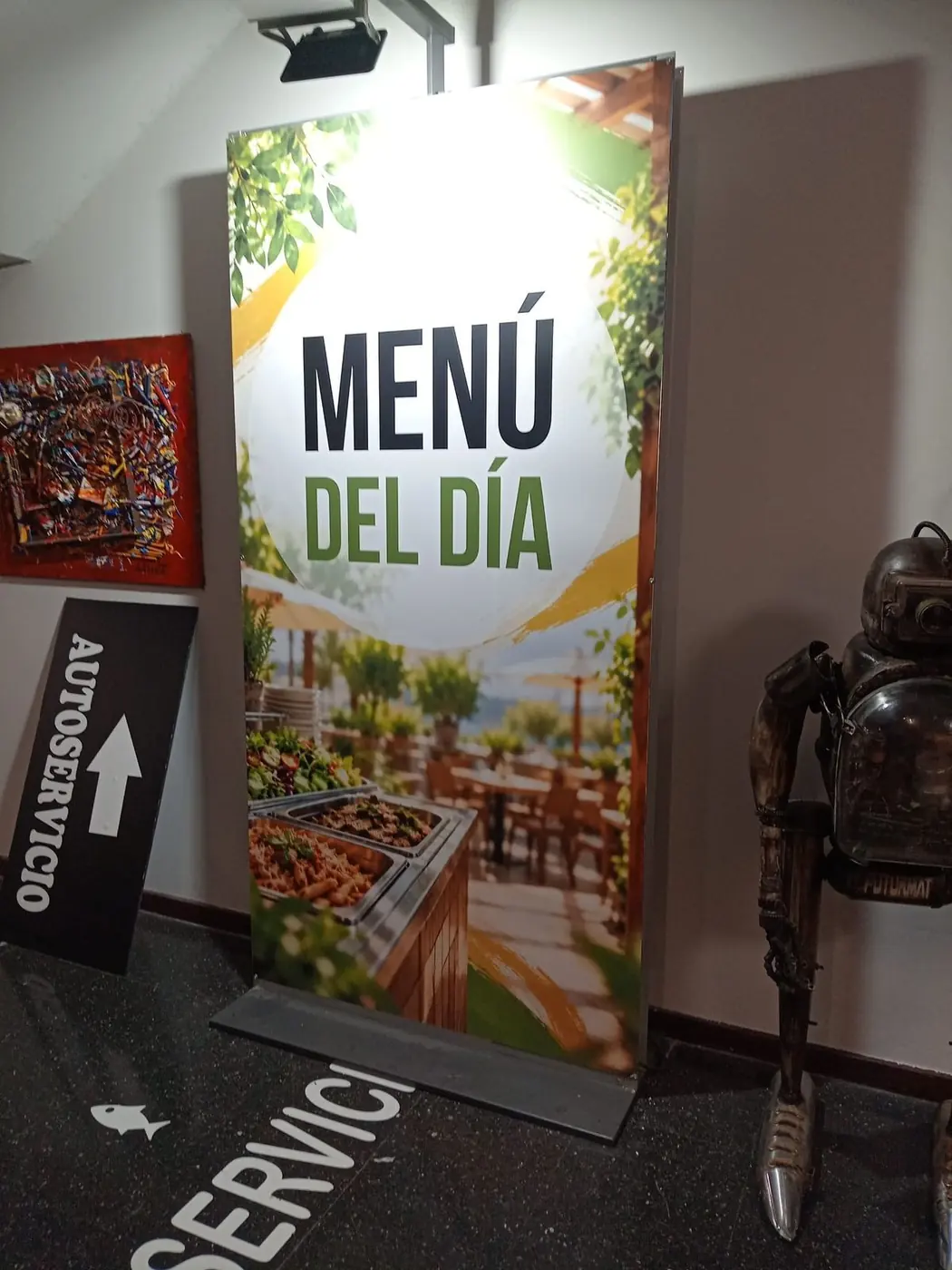 Expositor con el cartel impreso Menú del día junto a la entrada de un restaurante
