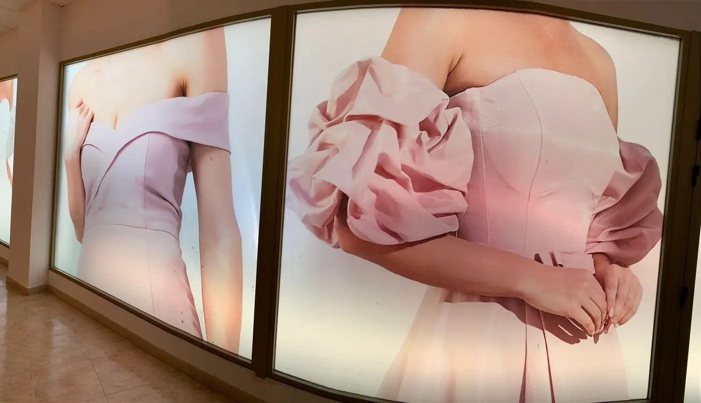 Detalle de un retroiluminado con la imagen de un vestido rosa de manga abullonada