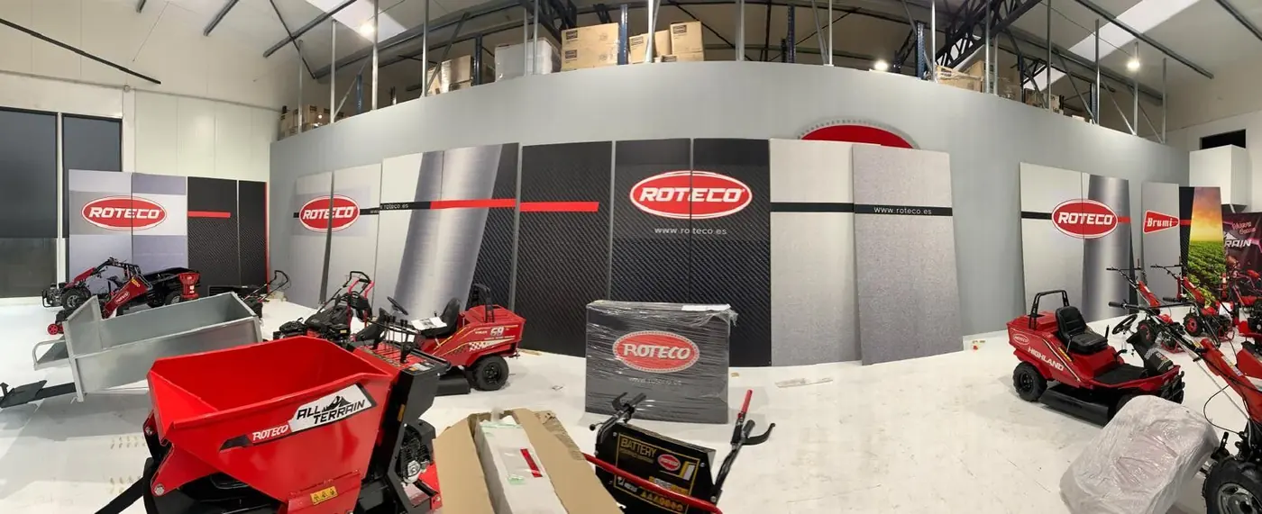 Sala de exposición de Roteco con vinilo panorámico gris y rojo sobre las paredes y maquinaria expuesta
